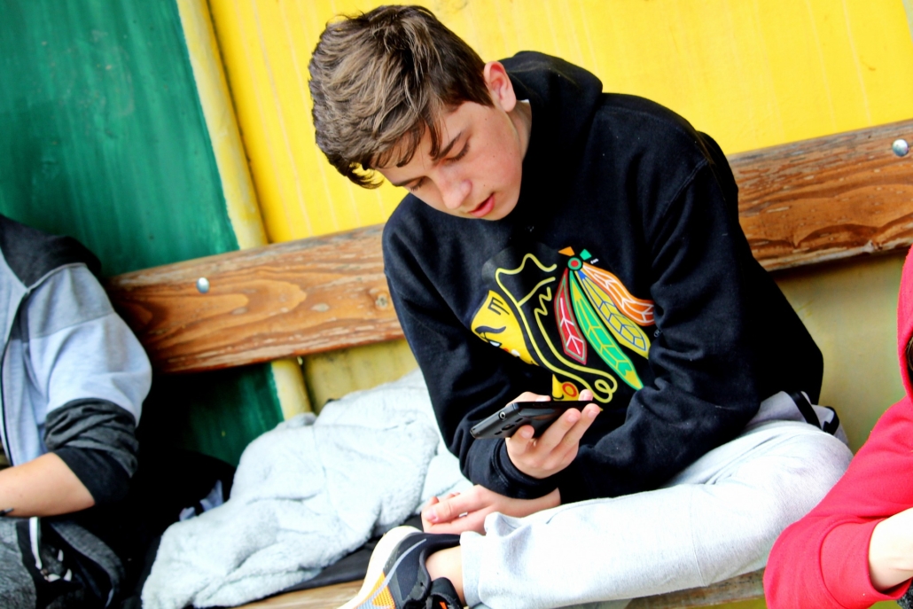 Studien_Mediennutzung Kinder und Handy Junge sitzt auf Boden