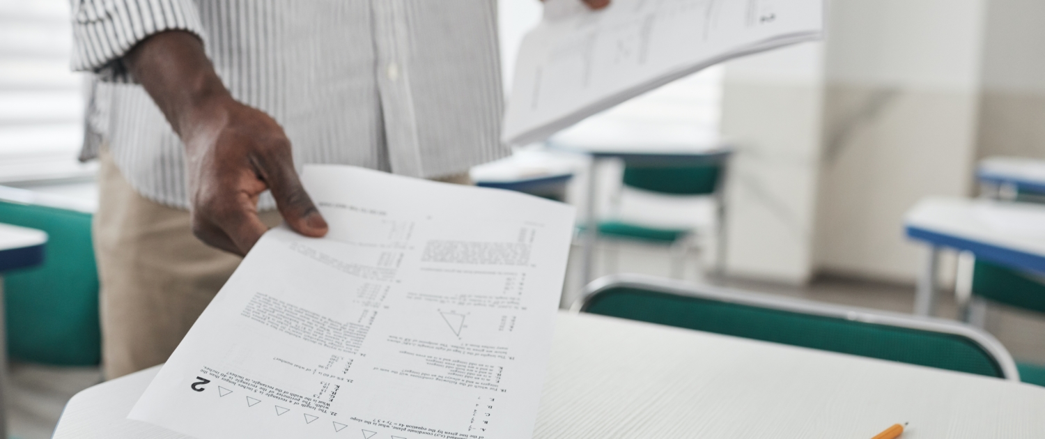 Lehrer teilt Arbeitsblatt aus