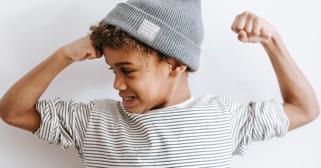 Zu sehen ist ein Kind, das eine starke Armbewegung macht, als Sinnbild für Resilienzförderung.