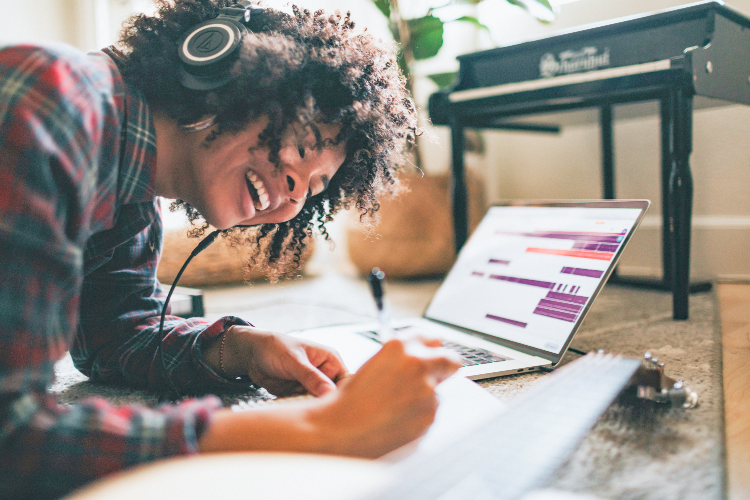 Junge Frau hat Kopfhörer auf und schreibt sie lernt Fremdsprachen mit der Birkenbihl-Methode.
