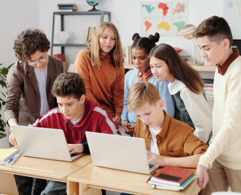 Lehrerin, die gemeinsam mit Schüler*innen arbeitet.